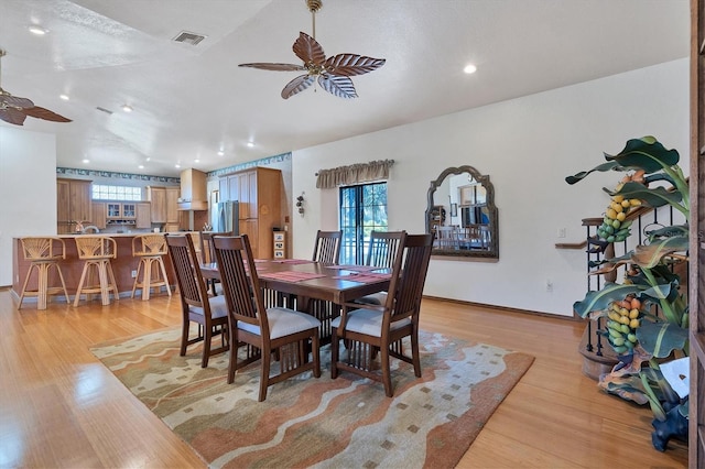 dining space with ceiling fan, a healthy amount of sunlight, and light hardwood / wood-style floors