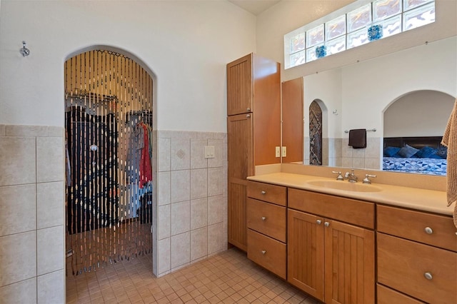 bathroom featuring vanity, tile patterned floors, and tile walls