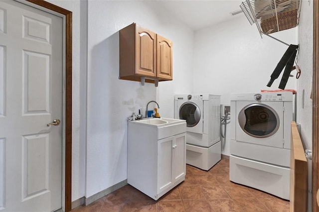 washroom featuring washer and dryer, cabinets, light tile patterned floors, and sink