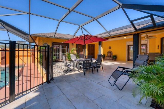 view of patio featuring glass enclosure and ceiling fan