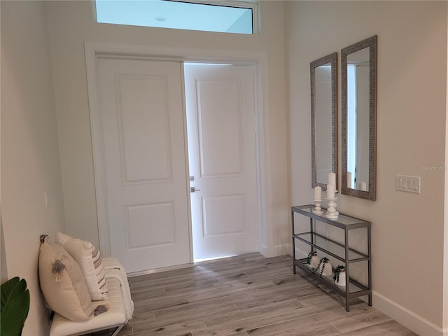 foyer featuring light wood-style flooring and baseboards