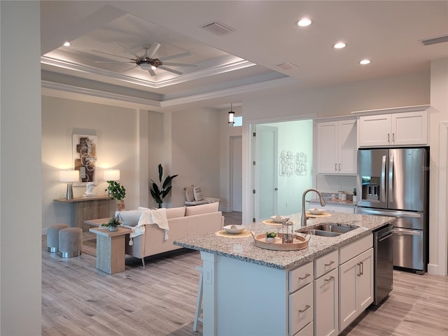 14331 Montmarte Ave, Port Charlotte, FL 33981 - kitchen with appliances with stainless steel finishes, a sink, a raised ceiling, white cabinets, and light stone countertops