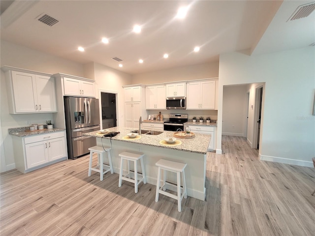 kitchen with visible vents, appliances with stainless steel finishes, white cabinets, and a sink