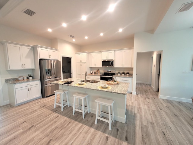 14331 Montmarte Ave, Port Charlotte, FL 33981 - kitchen featuring appliances with stainless steel finishes, a sink, light wood-style floors, white cabinetry, and recessed lighting