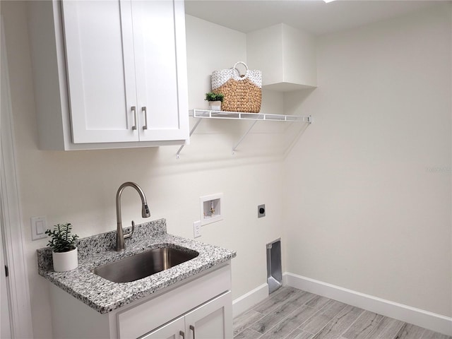 laundry room with baseboards, light wood-style flooring, a sink, hookup for a washing machine, and electric dryer hookup