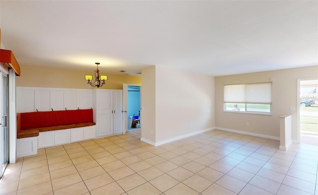 unfurnished room with light tile patterned flooring and an inviting chandelier