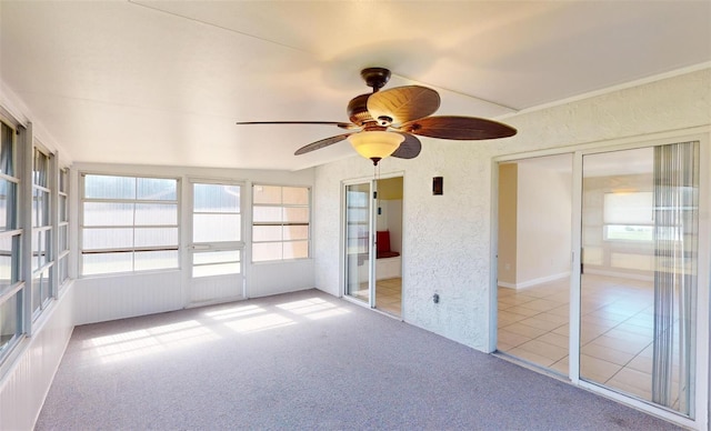 unfurnished sunroom with ceiling fan