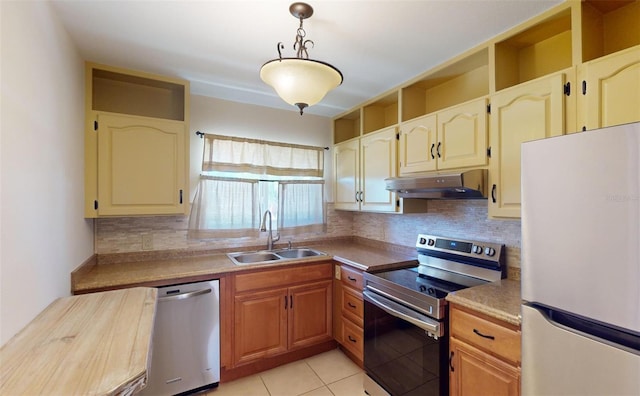 kitchen featuring sink, stainless steel appliances, tasteful backsplash, decorative light fixtures, and light tile patterned floors