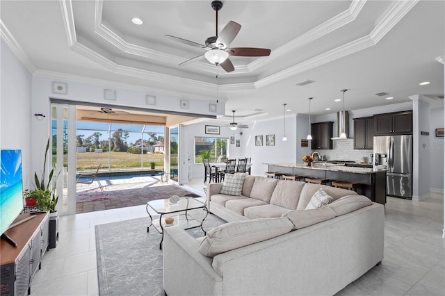 tiled living room with a raised ceiling and crown molding