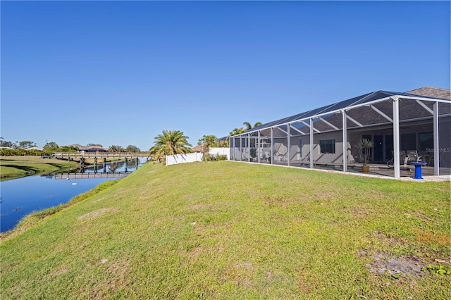 view of yard with glass enclosure and a water view