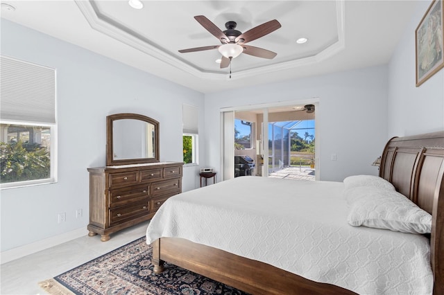 bedroom featuring access to outside, a raised ceiling, multiple windows, and ceiling fan