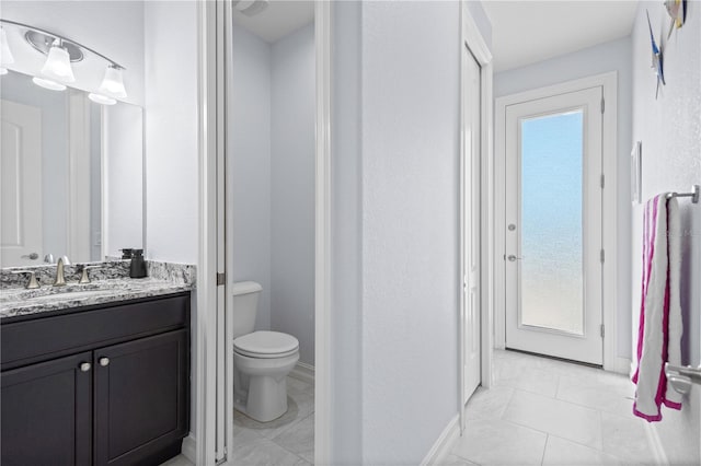 bathroom featuring tile patterned floors, vanity, and toilet