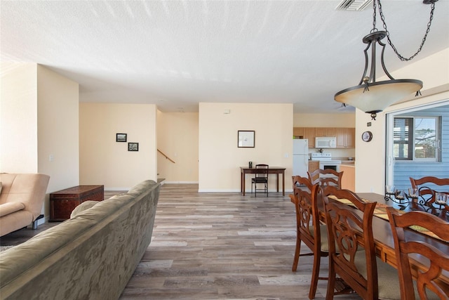 dining space with a textured ceiling and hardwood / wood-style flooring