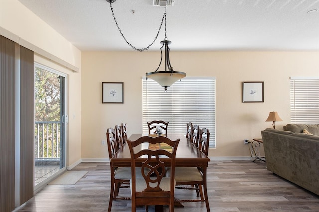 dining space with a textured ceiling and hardwood / wood-style flooring