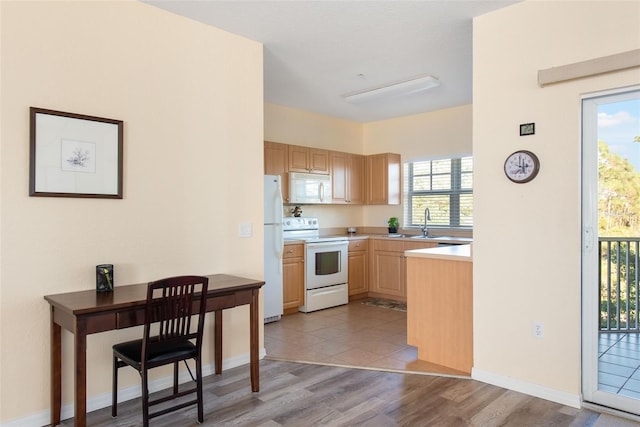 kitchen with light brown cabinets, a healthy amount of sunlight, white appliances, and light wood-type flooring