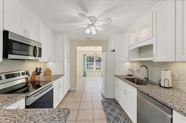 kitchen featuring white cabinets, sink, light tile patterned floors, light stone countertops, and appliances with stainless steel finishes