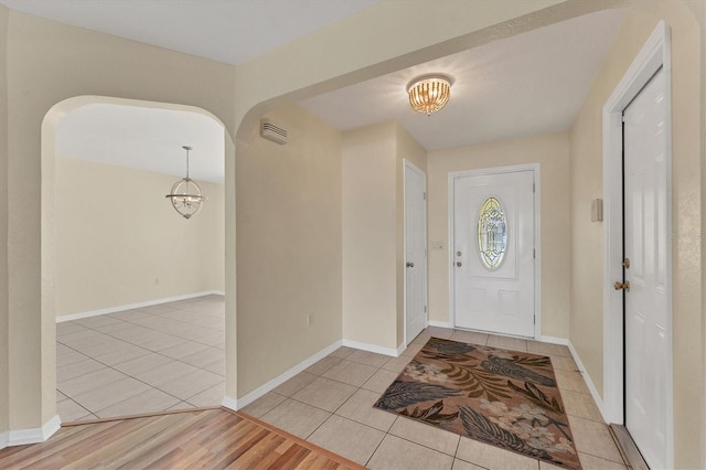 entryway featuring light hardwood / wood-style flooring and a chandelier