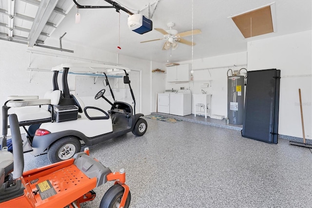 garage featuring washing machine and clothes dryer, ceiling fan, sink, electric water heater, and a garage door opener