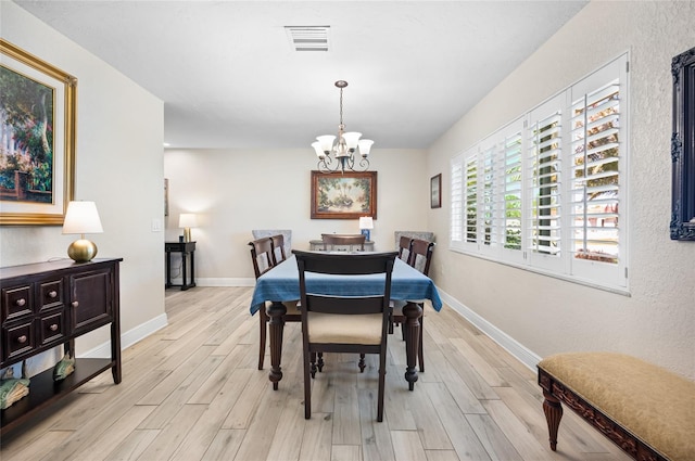 dining area featuring light hardwood / wood-style flooring and an inviting chandelier