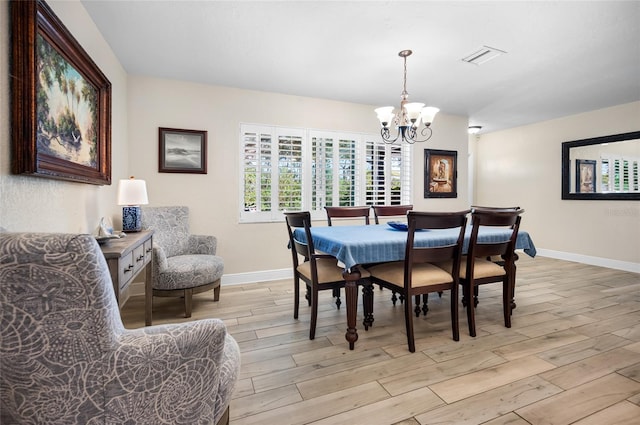 dining area featuring light hardwood / wood-style flooring and a notable chandelier