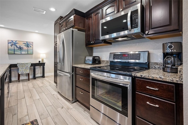 kitchen featuring light stone countertops, dark brown cabinets, stainless steel appliances, and light hardwood / wood-style flooring