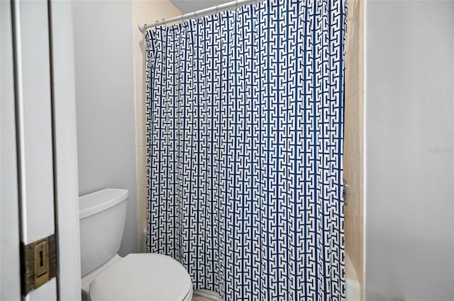 bathroom featuring toilet and shower / bath combo with shower curtain