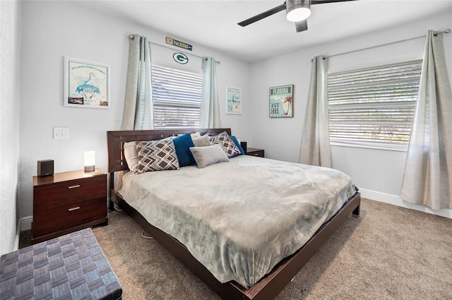 carpeted bedroom with ceiling fan and multiple windows