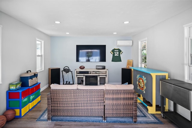 living room featuring an AC wall unit and dark hardwood / wood-style floors