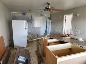 kitchen featuring white refrigerator, ceiling fan, and light tile patterned flooring