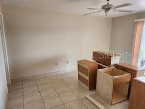 empty room with ceiling fan and light tile patterned floors