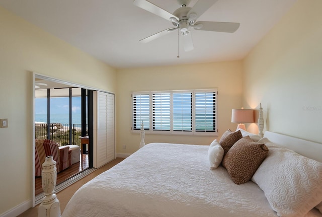 bedroom with access to exterior, ceiling fan, and a water view