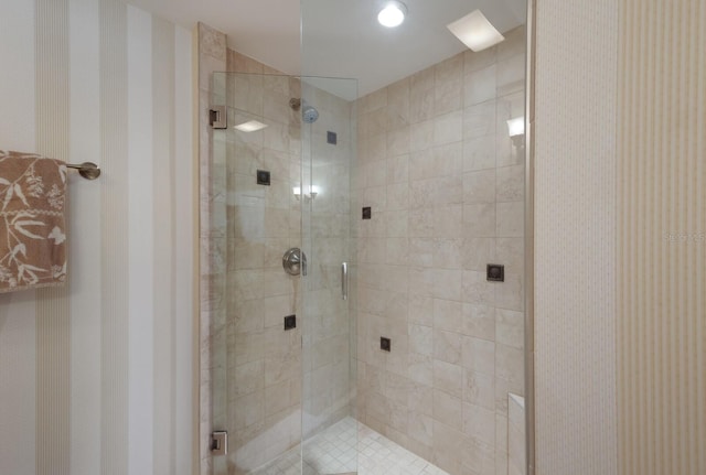 bathroom featuring a shower with door