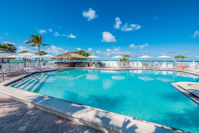 view of pool featuring a patio area and a water view