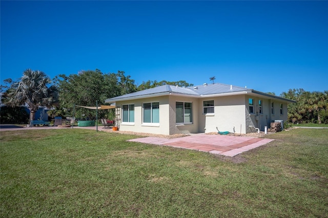 back of house with a patio and a lawn