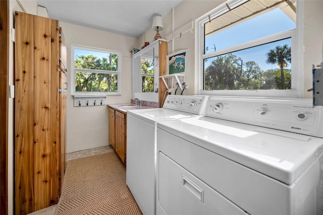 laundry room with separate washer and dryer, sink, and cabinets