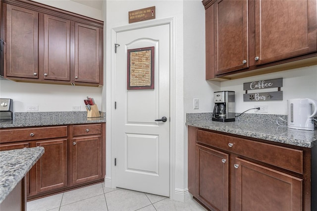 kitchen featuring dark stone countertops and light tile patterned flooring