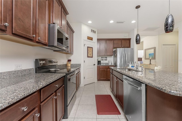 kitchen with stone counters, sink, hanging light fixtures, light tile patterned floors, and appliances with stainless steel finishes