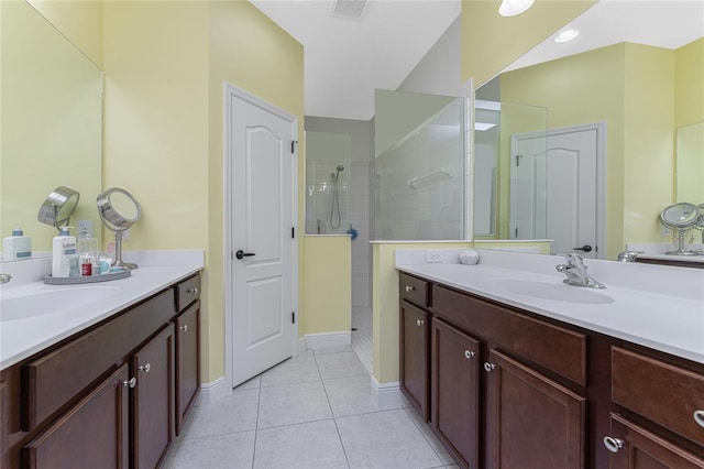 bathroom with tiled shower, vanity, and tile patterned floors