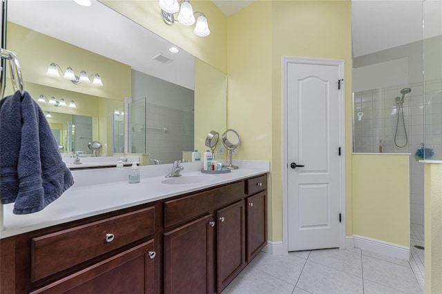 bathroom with tile patterned floors, vanity, and tiled shower