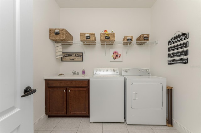 washroom with separate washer and dryer, sink, light tile patterned floors, and cabinets