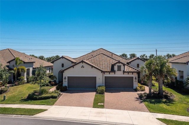 mediterranean / spanish house featuring a front yard and a garage