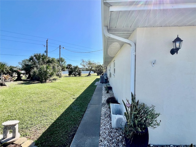 view of home's exterior featuring central AC unit and a yard