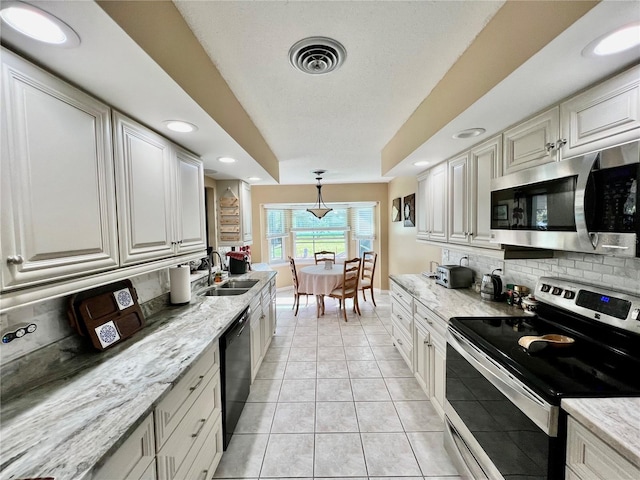 kitchen featuring sink, stainless steel appliances, decorative light fixtures, decorative backsplash, and light tile patterned floors