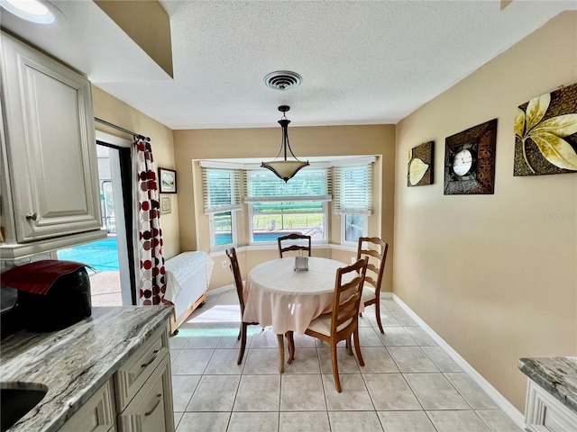 dining room featuring light tile patterned flooring and a textured ceiling