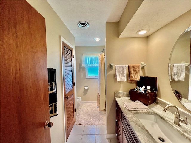 bathroom featuring tile patterned floors, vanity, a textured ceiling, toilet, and curtained shower