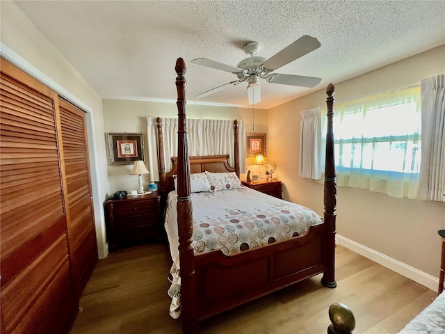 bedroom featuring hardwood / wood-style floors, a textured ceiling, a closet, and ceiling fan