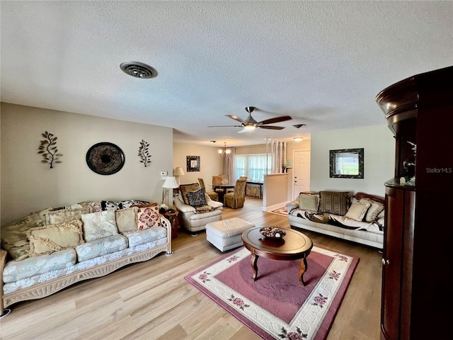 living room with ceiling fan, wood-type flooring, and a textured ceiling