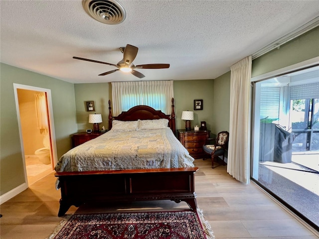 bedroom featuring ensuite bath, ceiling fan, light hardwood / wood-style floors, and a textured ceiling