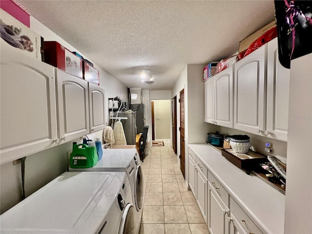 clothes washing area featuring independent washer and dryer, a textured ceiling, and light tile patterned floors