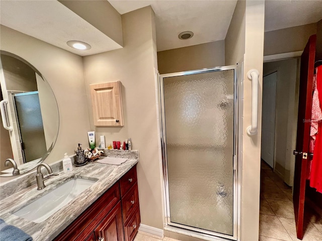 bathroom with tile patterned floors, vanity, and a shower with shower door